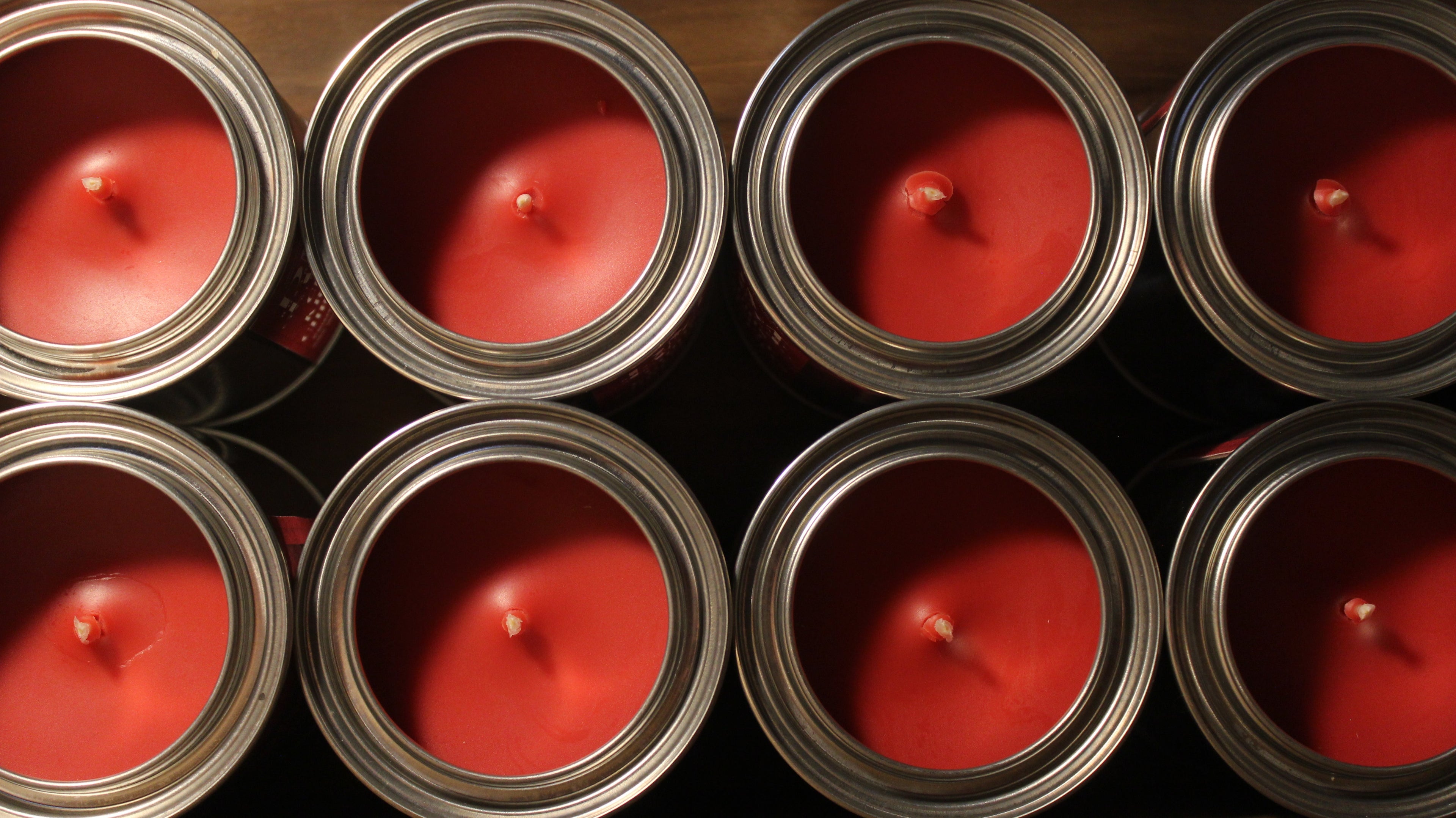 Red colored candles in rustic metal tins
