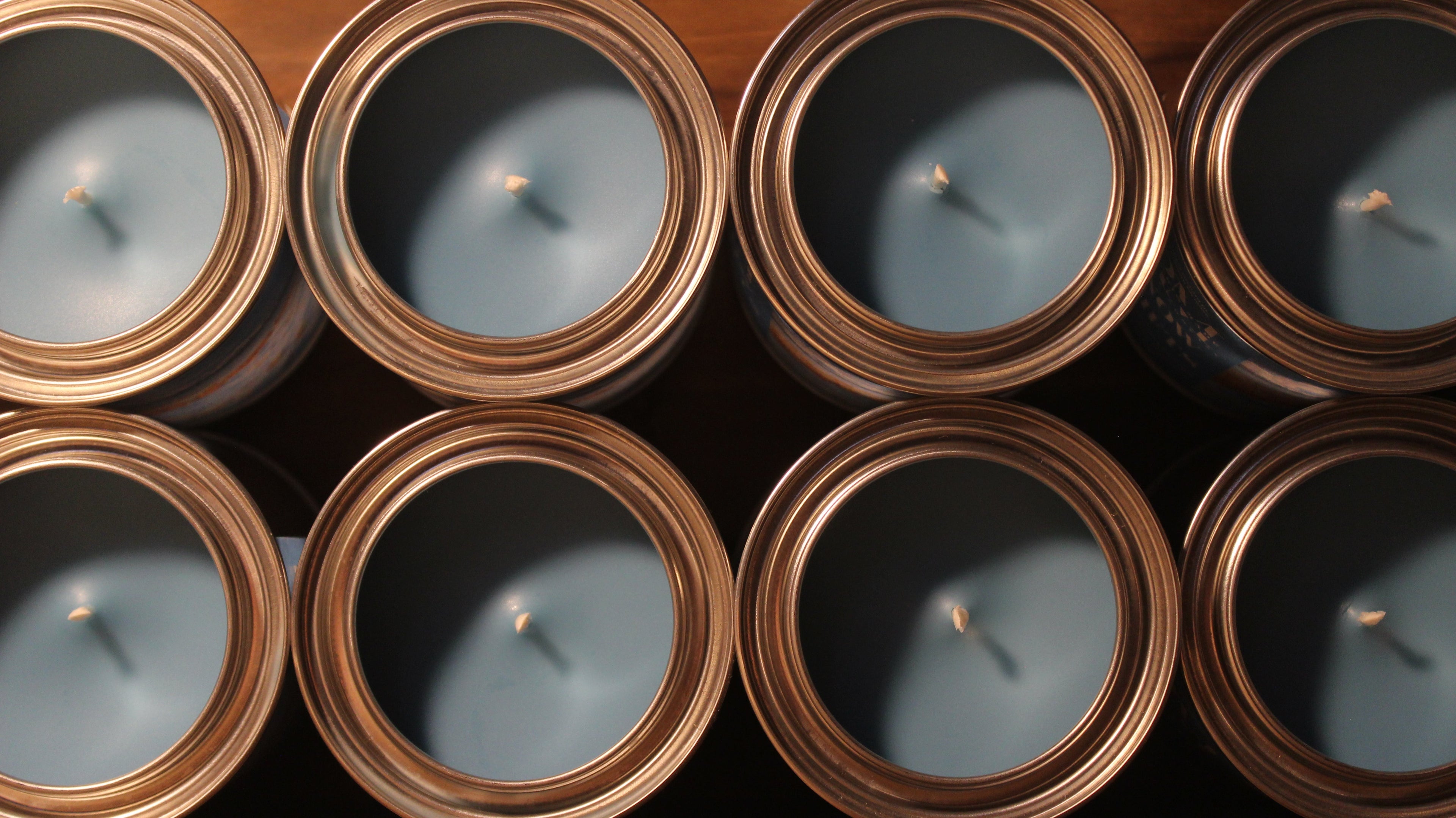 Blue colored candles in rustic metal tins 