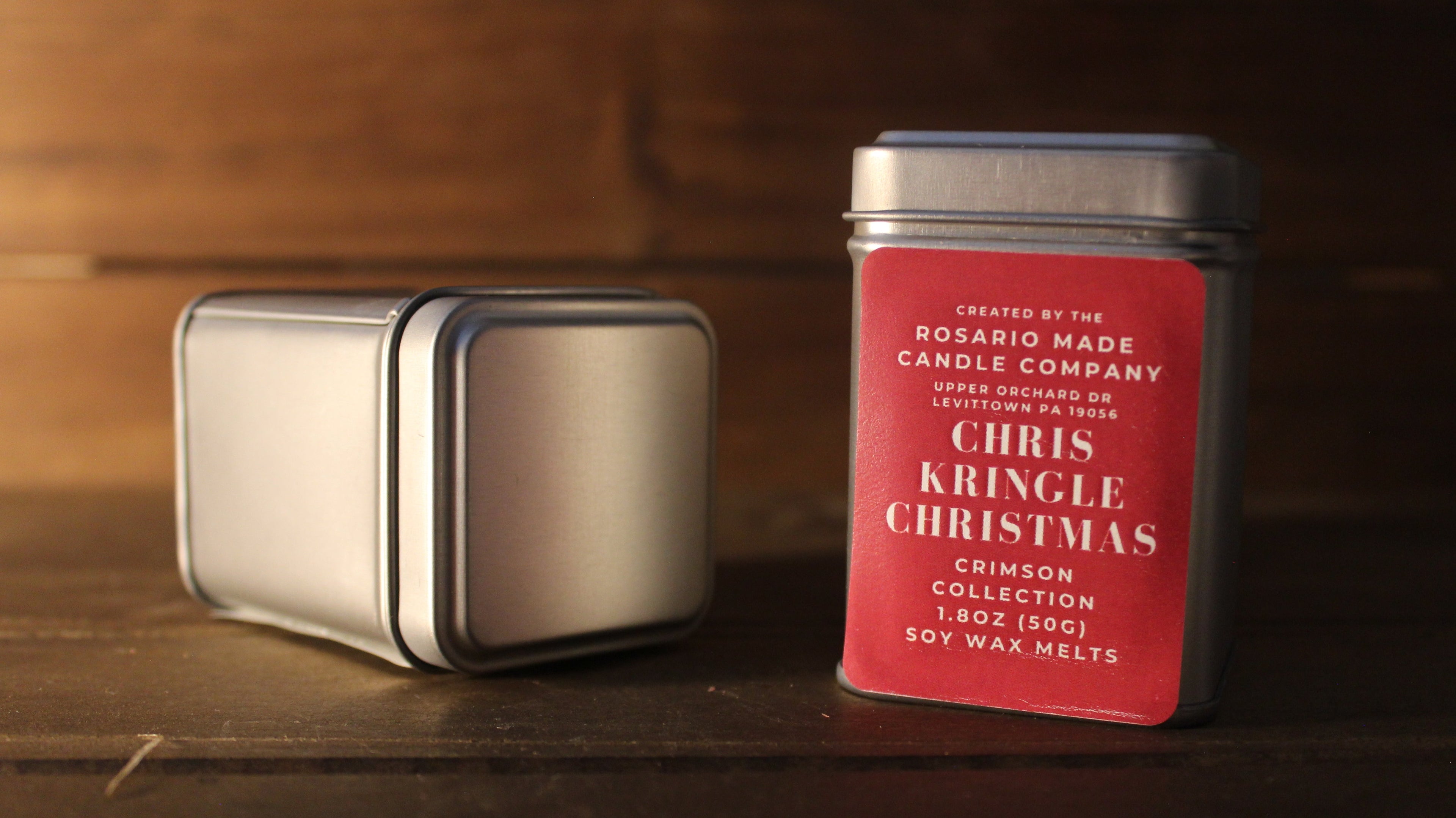 Cranberry and spice scented wax melts in rustic metal tins on a wooden surface