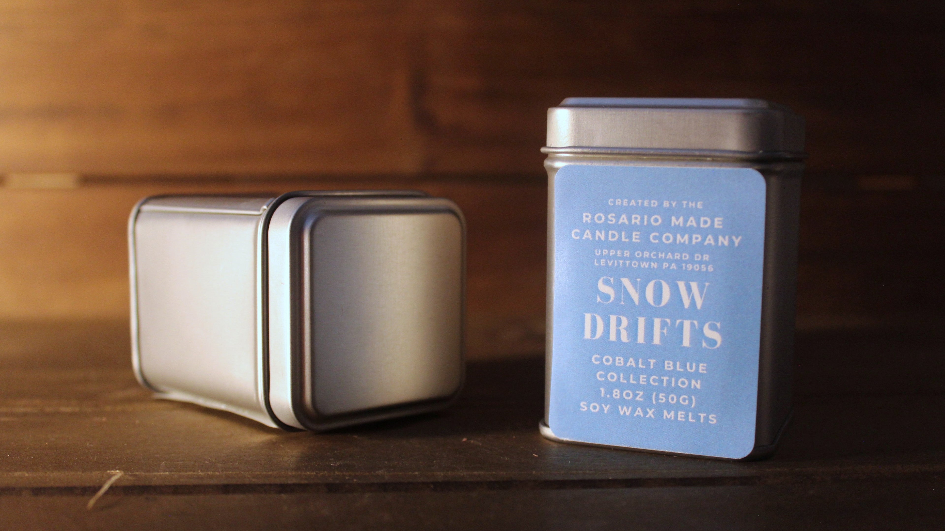 Eucalyptus and juniper scented wax melts in rustic metal tins on a wooden surface