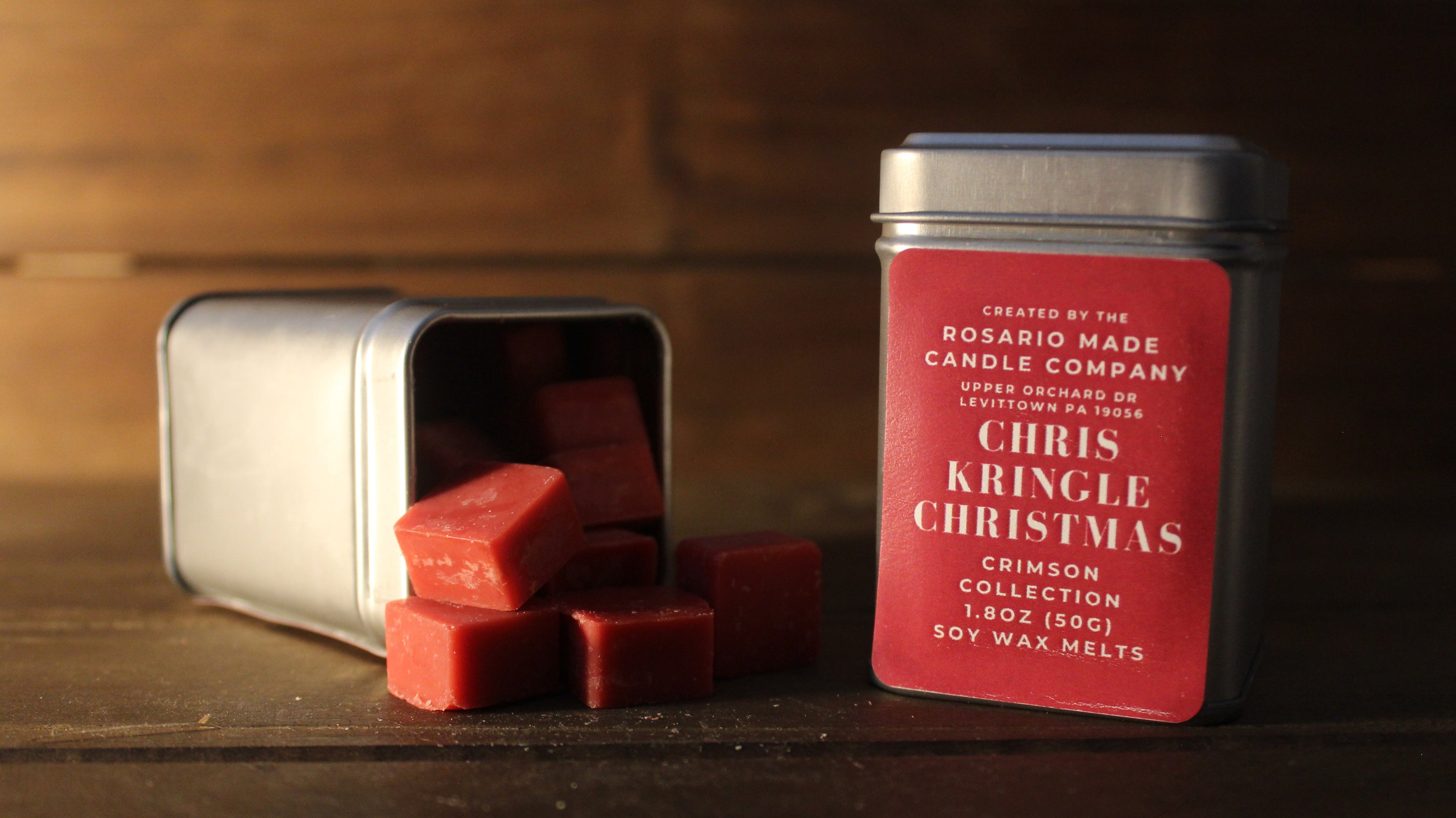 Cranberry and spice scented wax melts in rustic metal tins on a wooden surface