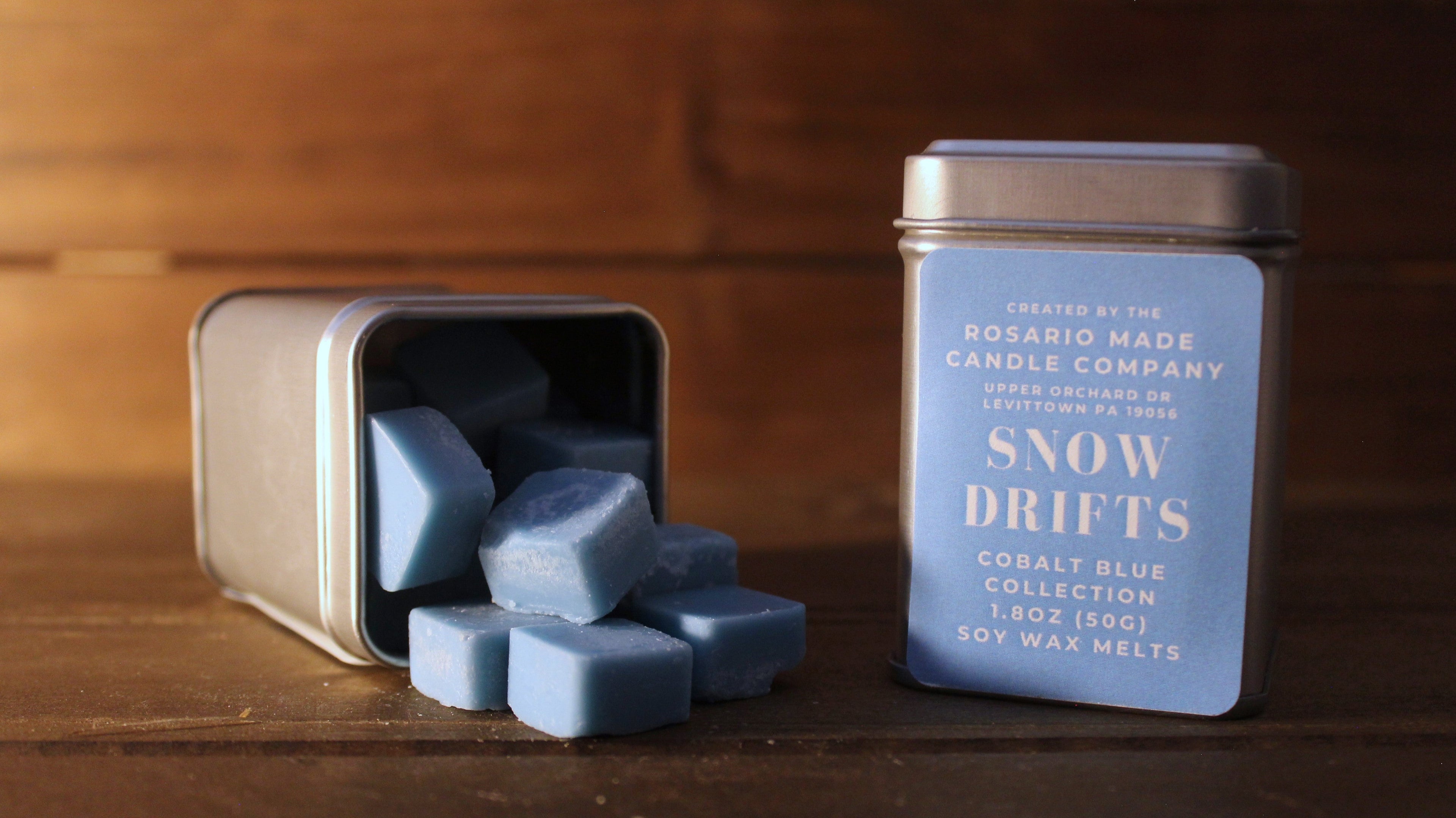 Eucalyptus and juniper scented wax melts in rustic metal tins on a wooden surface